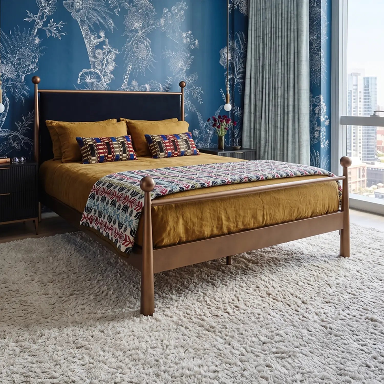 Olympus Iron Bed shown in Opaque Copper Finish with Black Velvet Performance Fabric. The Olympus bed is shown in a modern eclectic design with royal blue, floral wallpaper and gold velvet bedding.