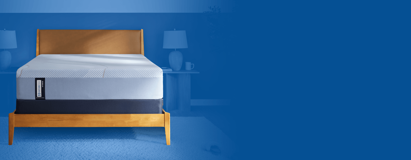 Posturepedic Hybrid mattress in a styled room with a blue background